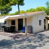 Bungalow bianco con terrazza e tenda gialla.