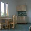 Cucina con tavolo e sedie in legno e mobili beige.