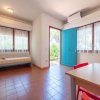 Stanza luminosa con divano, tavolo e porta blu aperta.