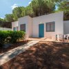 Villetta bianca con porta blu e area patio.
