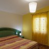 Camera con letto matrimoniale e parete gialla.