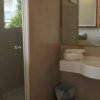 Bagno con doccia, lavandino e specchio.