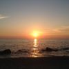 Un tramonto sull'oceano con cielo blu e arancione.