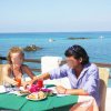 Coppia che mangia davanti al mare.