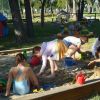 Bambini giocano con secchielli e palette in una sabbiera in un parco giochi.