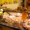 Interno di una salumeria italiana con vetrina di formaggi e prodotti da forno.