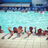 Persone sorridenti in piscina.