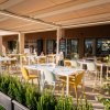Ristorante all'aperto con tavoli e sedie colorati.
