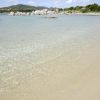 Spiaggia con acqua trasparente e sabbia chiara.