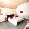 Camera da letto con soffitto in pietra, letto matrimoniale e pareti bianche.