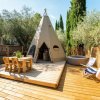 Tenda a forma di tipì su una terrazza in legno.