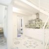 Cucina bianca con decorazioni floreali.