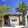 Ingresso con insegna e palme.