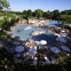 Piscina circondata da ombrelloni bianchi e lettini.
