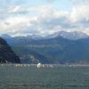 Regata su un lago circondato da montagne con cielo nuvoloso.