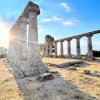 Rovine di un tempio antico con colonne illuminate dal sole.
