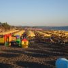 Spiaggia con ombrelloni e area giochi colorata.