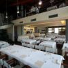 Sala da pranzo elegante con tavoli apparecchiati e una scala a chiocciola sullo sfondo.