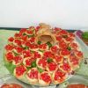 Bruschette con pomodori e olive su un piatto decorativo.