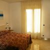 Camera da letto con letto matrimoniale, copriletto a motivi rossi e finestra luminosa.