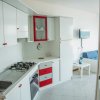 Cucina bianca e rossa con piano cottura.
