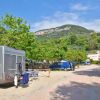 Un camper parcheggiato vicino ad alberi verdi e una strada sterrata.