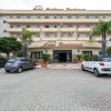 Facciata di un hotel con auto parcheggiate.