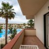 Balcone con vista piscina e palme.