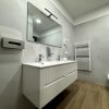 Bagno moderno con lavabo sospeso e specchio.