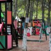 Parco giochi colorato tra gli alberi.