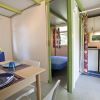 Interno di casa mobile con tavolo da pranzo, cucina compatta e camera da letto.