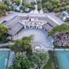 Vista aerea di un edificio con campi sportivi e piscina.
