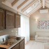 Cucina moderna con travi a vista e divano beige.