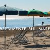 Spiaggia con ombrelloni colorati e sedie a sdraio.