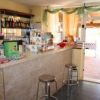 Bancone bar con sgabelli, snack confezionati e uscite verso l'esterno.