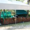 Area camping con gazebo, recinto di legno e decorazioni floreali.