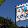 Cartello del Camping Rio Martino tra la vegetazione.