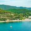 Spiaggia e colline verdi viste dall'alto.