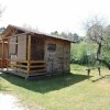 Una piccola cabina di legno con veranda immersa nel verde.