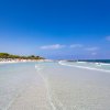 Spiaggia con mare trasparente e cielo blu.