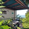 Terrazza con tavolo circondata da piante e vista sul mare.