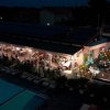 Ristorante affollato con piscina illuminata di notte.