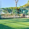 Donna gioca a tennis su un campo all'aperto.