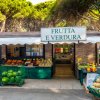 Negozio di frutta e verdura con frutta esposta fuori.