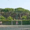Bambini giocano a calcio all'aperto, con un bambino che entra in campo.