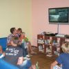 Gruppo di ragazzi in un salotto guarda la TV.