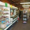 Interno di un minimarket con scaffali pieni di prodotti.