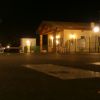 Edificio illuminato di sera su una strada asfaltata.