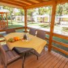 Veranda in legno con tavolo apparecchiato.